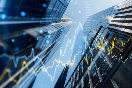 Financial district towers rising against an overlay of market movement